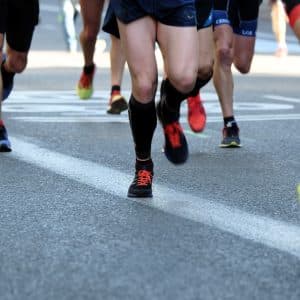 people running on gray asphalt road during daytime